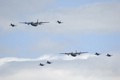 Two C-130 Hercules transports escorted by F-16s