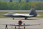 F-22 Raptor taxies past the GEICO Skytypers' T-6 Texans