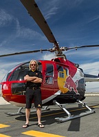Pilot Chuck 'Malibu' Aaron posing in front of his Red Bull Bo-105