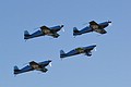 The Blades flying their Extra 300 LP aerobatic aircraft with the logo of the Royal Air Force Association below the wings highlighting their RAF backgrounds.