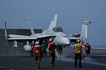 VFA-83 F/A-18C Hornet, hook man (green), catapult officer (yellow) and ordnancemen to arm the weapons