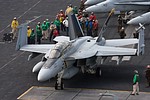 VFA-103 'Jolly Rogers' commander's F/A-18F Super Hornet in front of flight deck crew