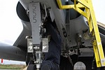 View of the front leg of the landing gear and a 331 Mira technician at work.