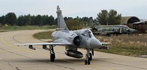 332 Mira Mirage 2000EGM 242 return to parking, passing a derelict RF-4 Phantom II airframe