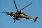 The AH-129D's gun is aimed at a target on the ground, ready to fire